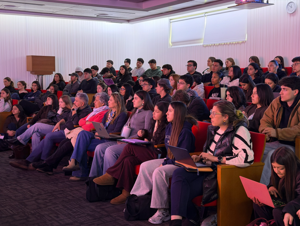 alumnos mirando exposición de agencia raya